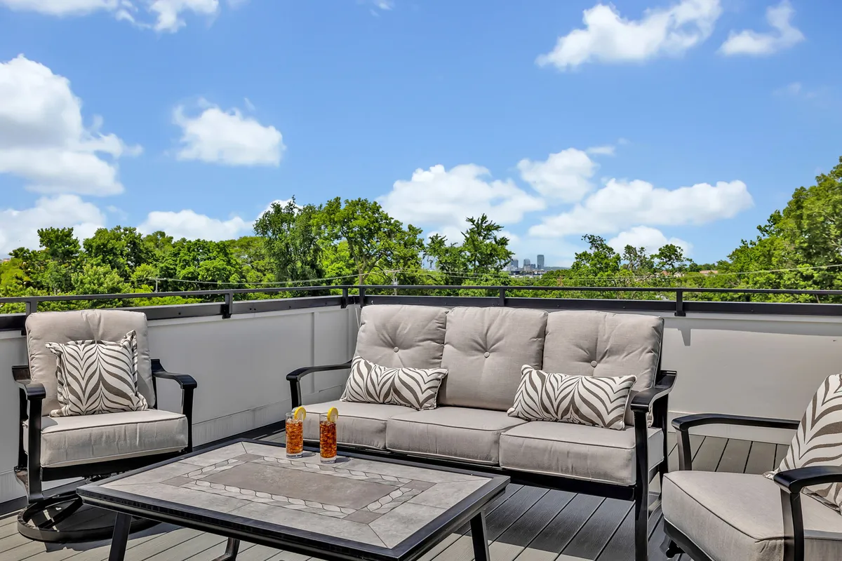 A cozy outdoor seating area with a coffee table surrounded by lush greenery, creating an intimate space for relaxation. The space suggests a peaceful retreat for morning coffee, sunset views, or unwinding after a day out.