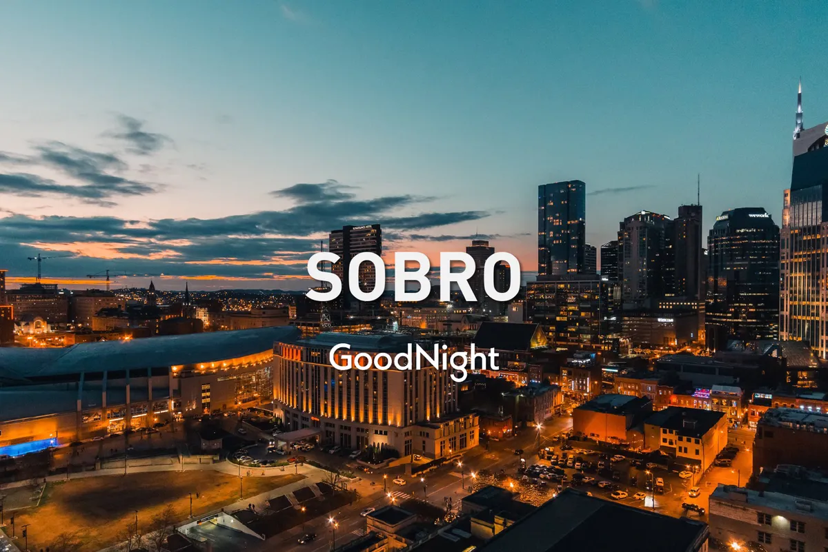 A panoramic, sunset-lit Nashville skyline with illuminated buildings. The energetic city atmosphere invites both business and leisure, evoking the potential for after-hours networking or relaxation with teammates while enjoying the views.