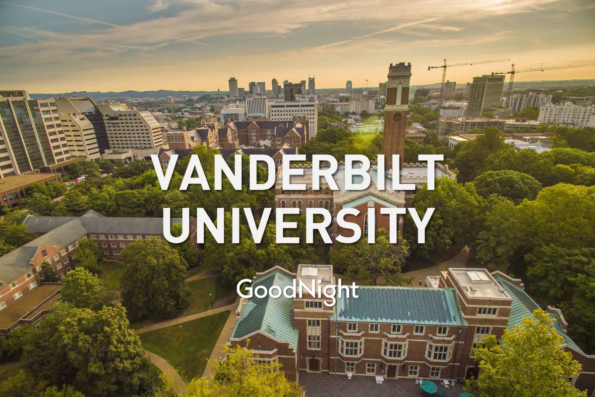 A wide view of Vanderbilt University’s classic buildings and clock tower, set against lush greenery and the city skyline. The scene is tranquil yet vibrant, suggesting both academic prestige and urban accessibility.